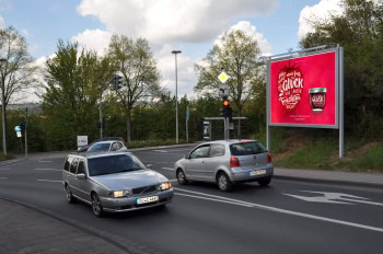 Grossfläche mit rotem Plakat an einer Ampel