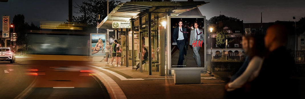 Plakattafel H&M an der Haltestelle am Sternenplatz bei Nacht